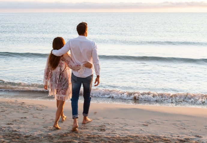 Aerial view of homes in Nassau County Florida with courts and pool, an older couple enjoying ice cream, and the exterior of a clubhouse with palm trees and flowers in the Wildlight master planned community.