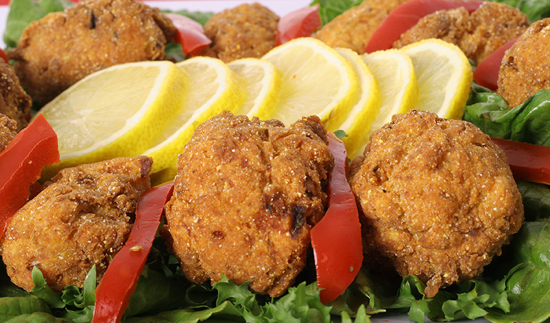 A plate of fried calamari with lemon wedges.