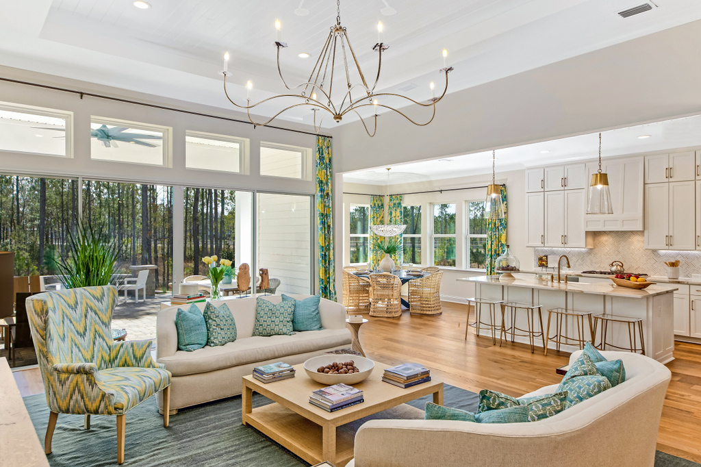 Riverside Homes lowcountry open concept living room and kitchen with large glass doors and windows that lead to the patio.