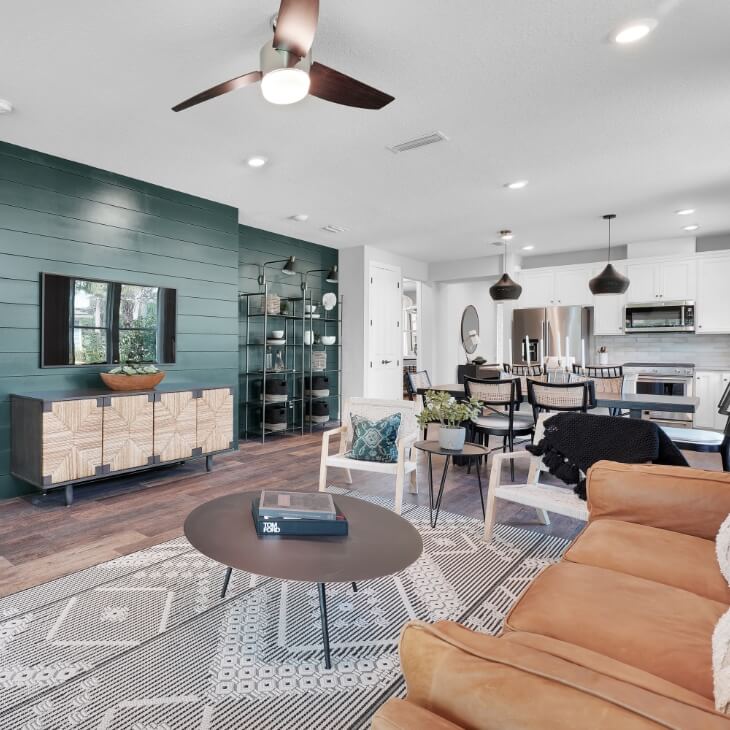 Open concept living room and kitchen with a green shiplap accent wall.