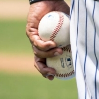 Close up of a pitcher holding two baseballs on a baseball field. 121 Financial Park is local spot for baseball..