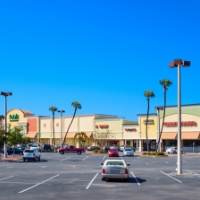 A parking lot and shopping center with palm trees like River City Marketplace