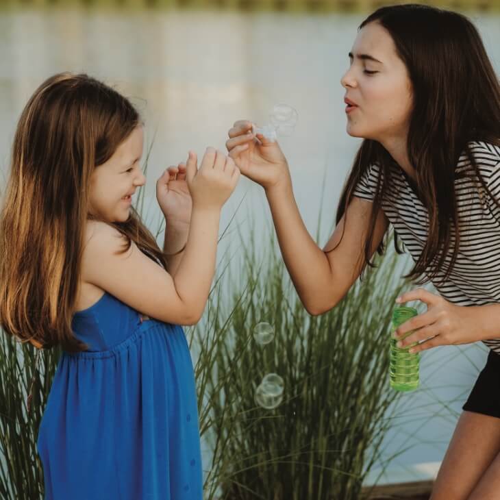 A mother and daughter blowing bubbles at Waterbug Park