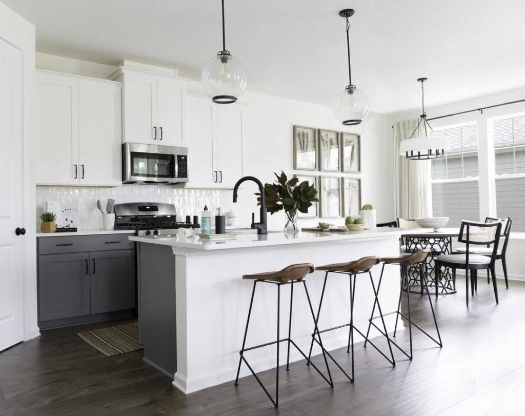 White open concept kitchen featuring an island with barstools.