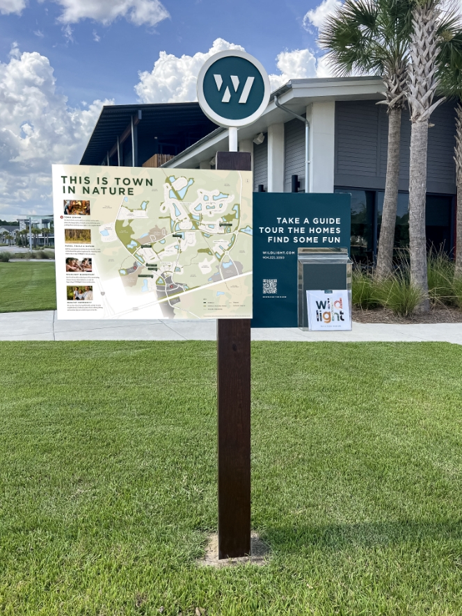 A sign with a map on it in front of a building.
