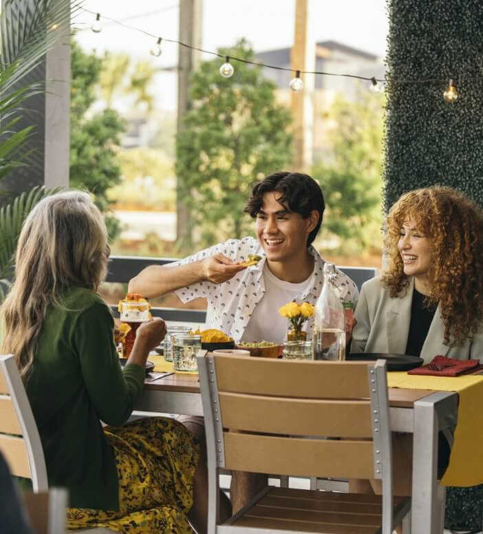 A group of people enjoying a meal at an outdoor restaurant.