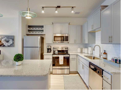 A kitchen with stainless steel appliances and granite counter tops.