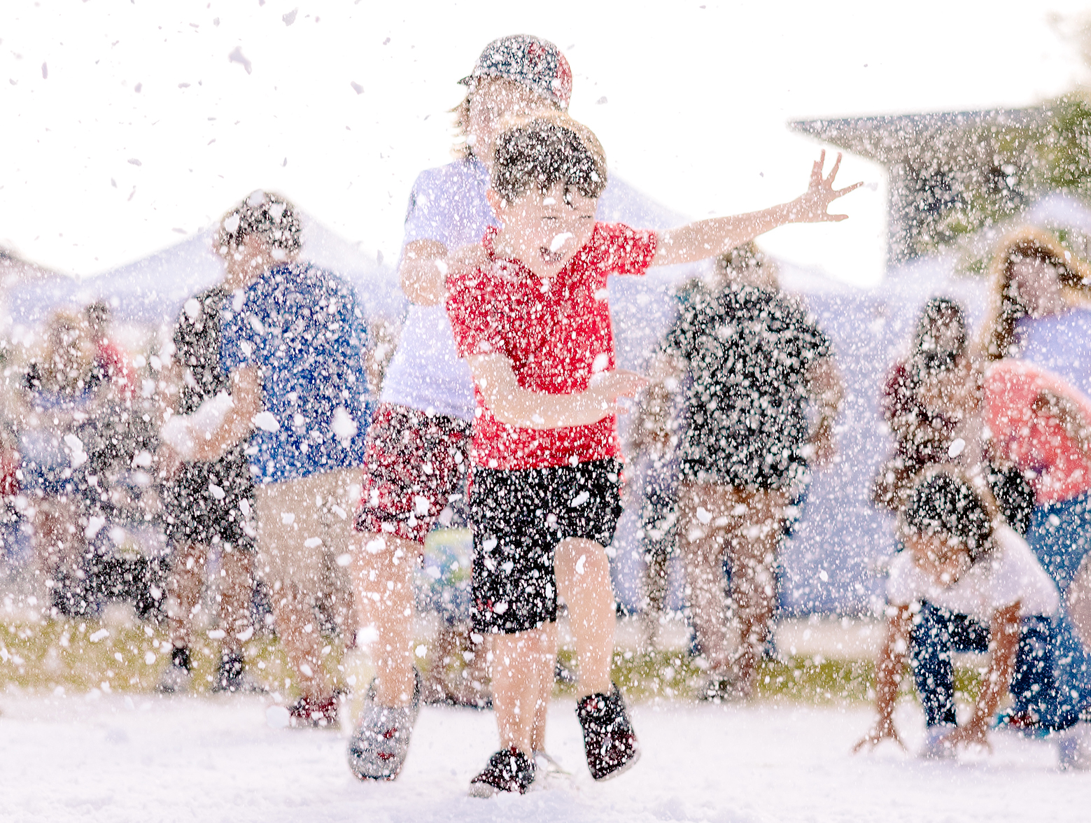 A group of children playing in the snow at an outdoor event.