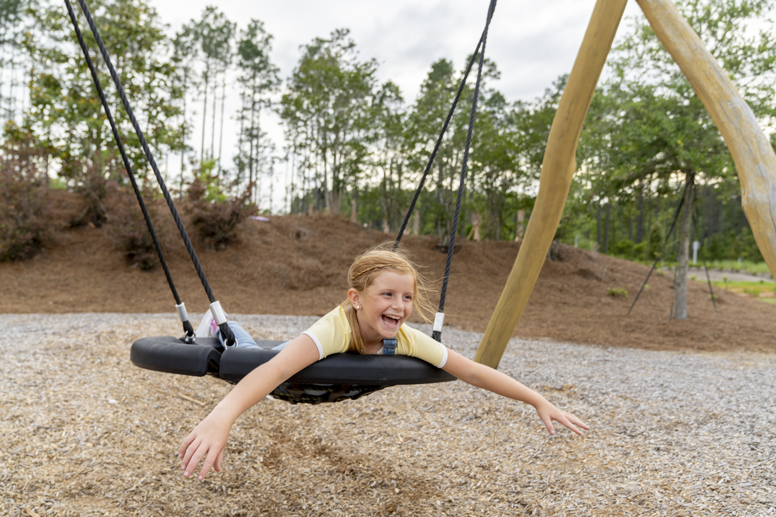 A young girl is swinging on a swing.