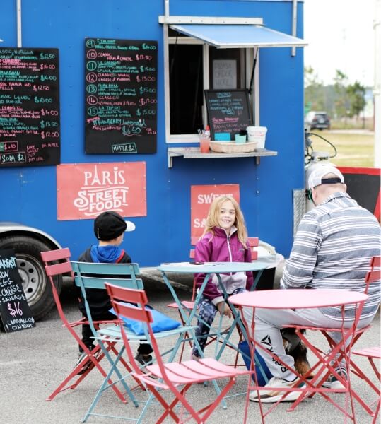 A family sits at a table at a food truck.