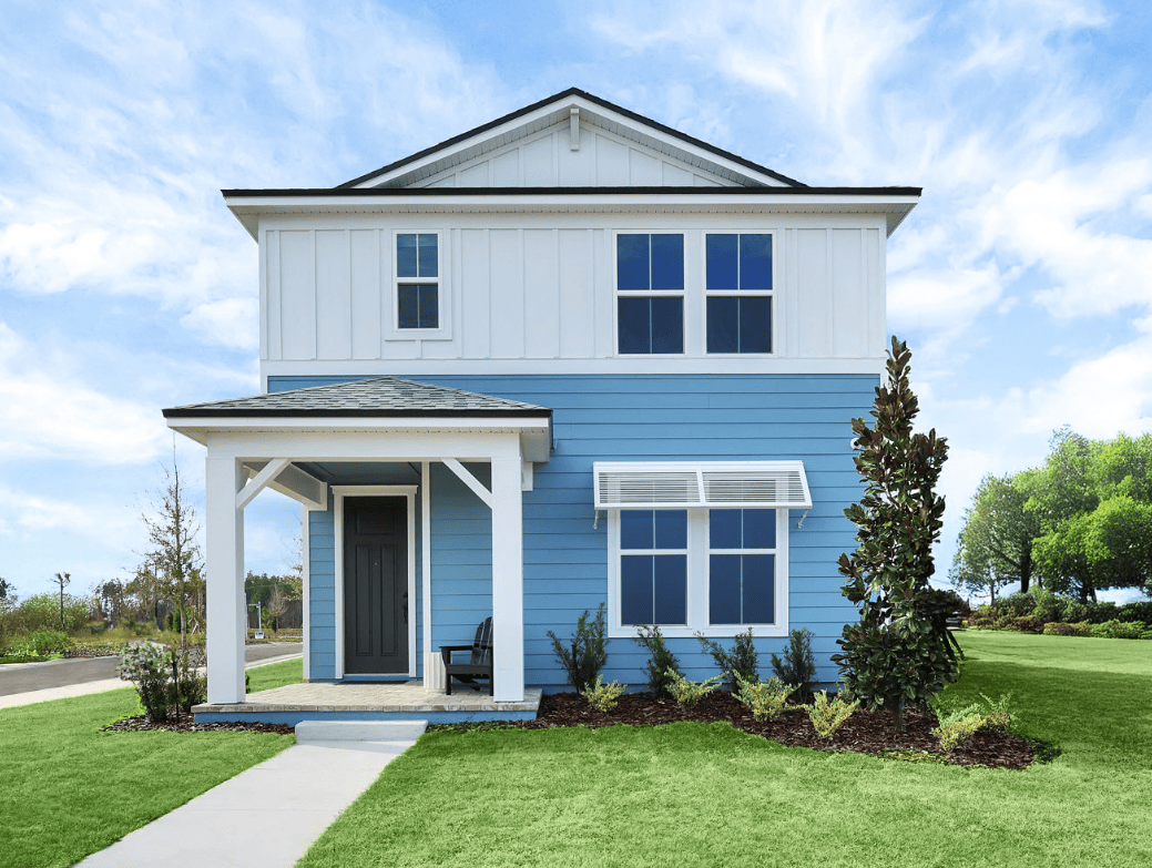 Two-story house with light blue and white exterior, front porch, dark door, and landscaped lawn on a sunny day—one of the charming new homes in Wildlight FL.