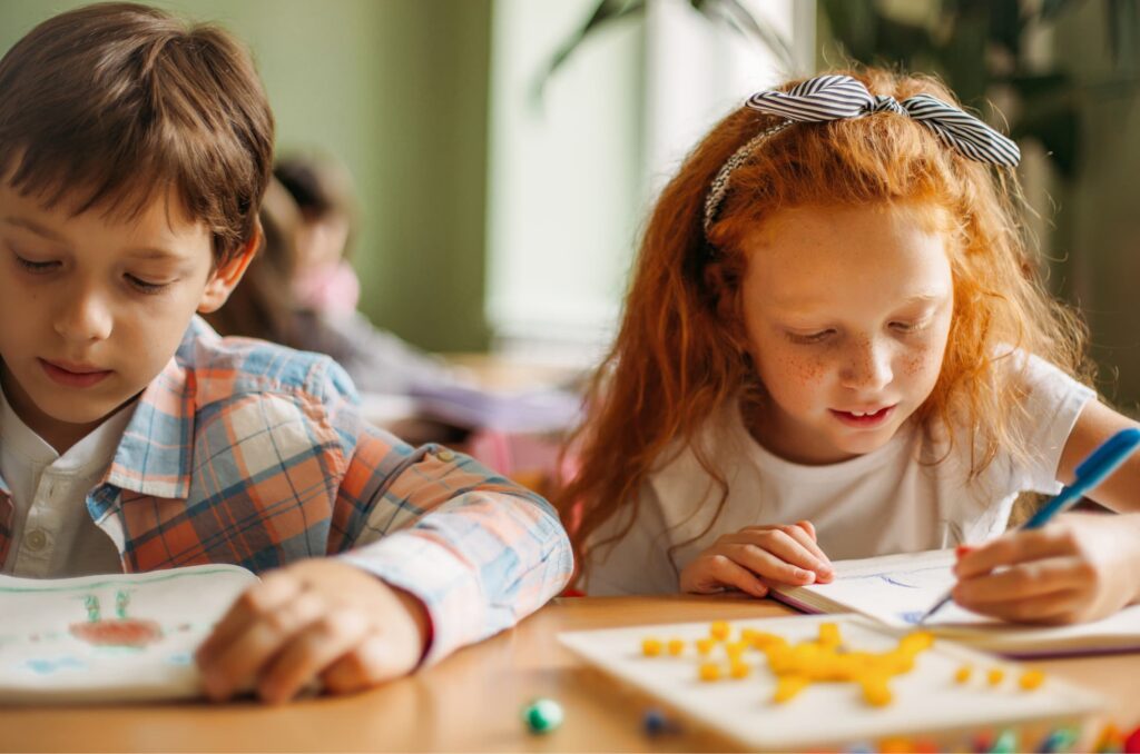 Children sitting at school desk drawing
