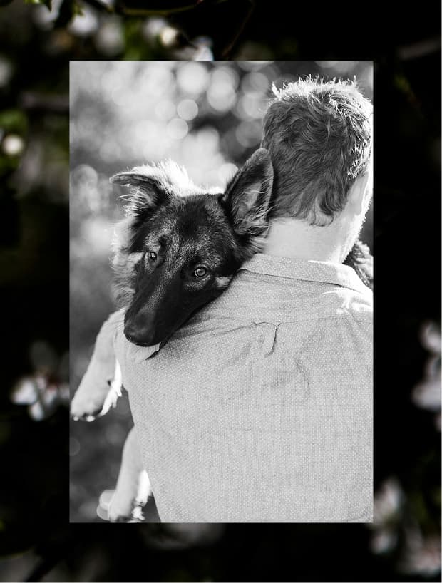 Man carrying dog in black and white