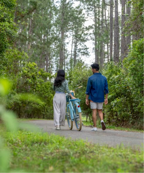 Couple walking a bicycle along a path