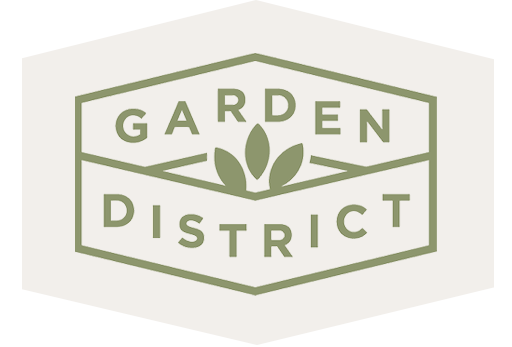 A hexagonal green outline with the words "Garden District" and three leaf shapes in the center, representing new homes in Wildlight FL and the vibrant Wildlight Yulee Florida community.