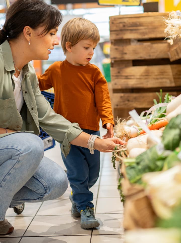 A mother and her child shopping for vegetables
