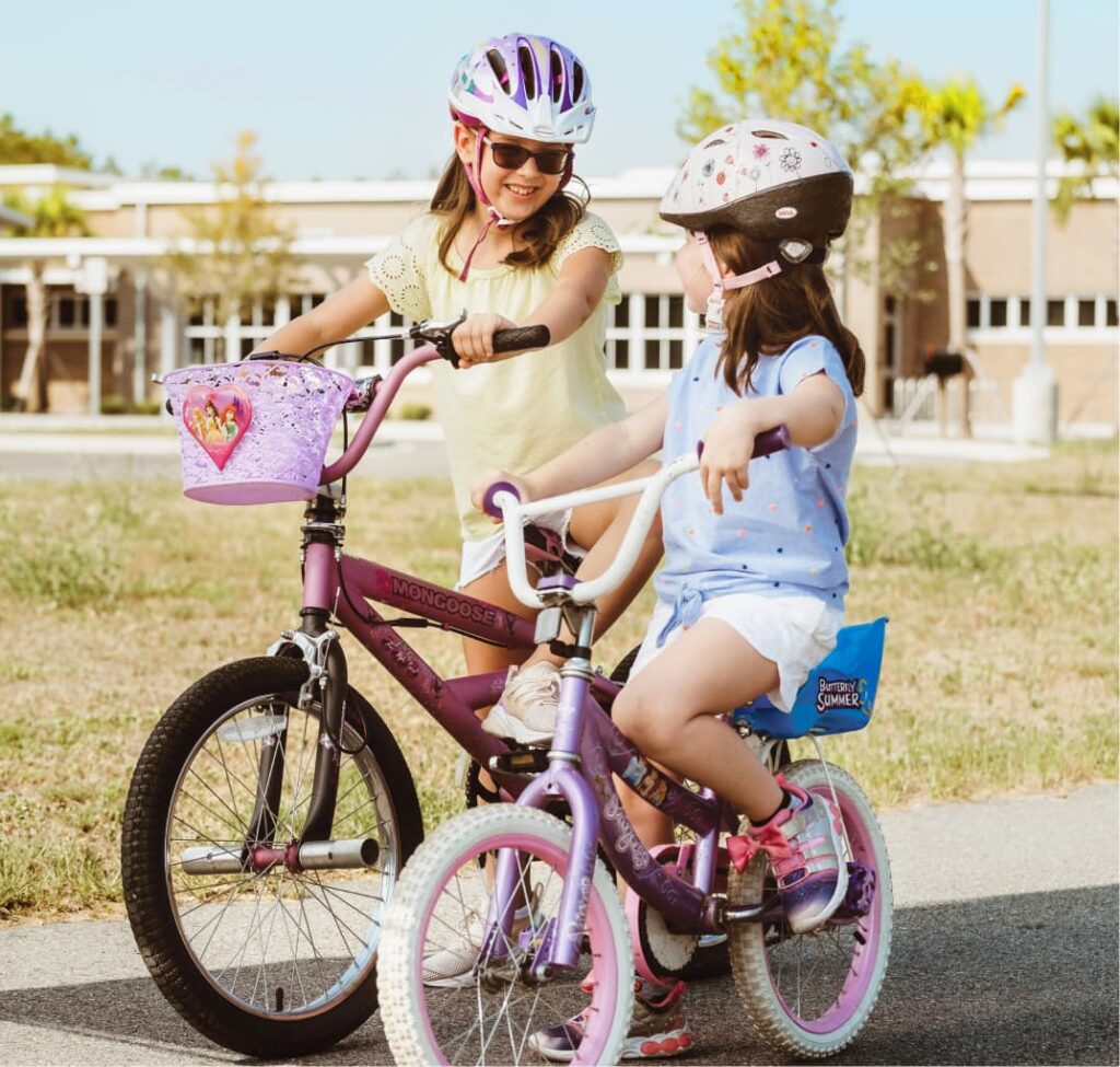 Two girls riding bicycles togetehr