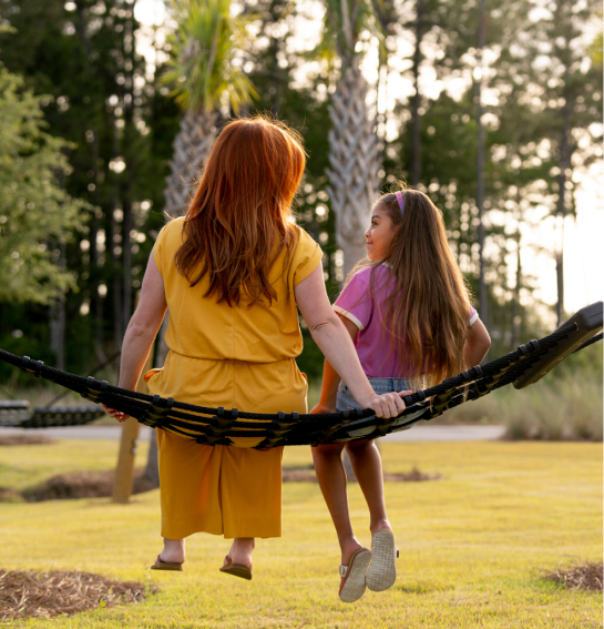 A mother and daughter resting on a hammock