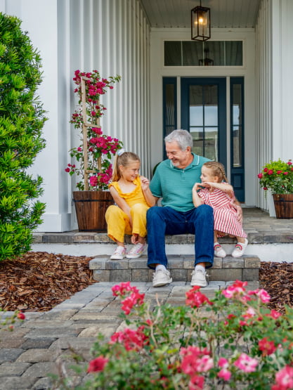 A Grandfather with children siting on a porch