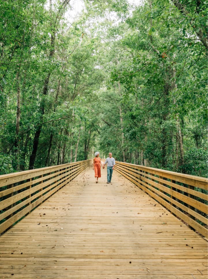 Older couple walking along a wooden bridge