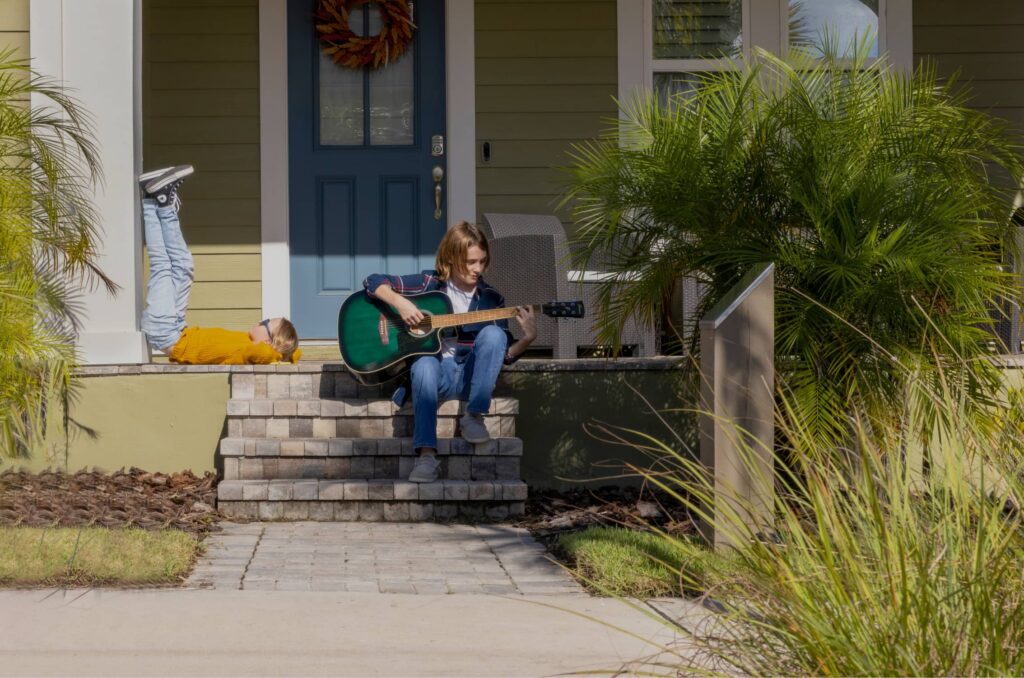 Woman playing guitar sitting on step