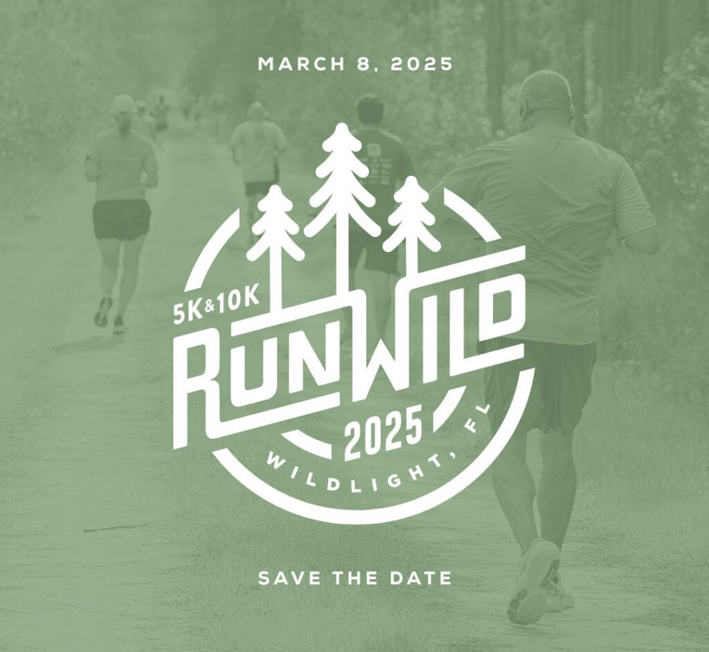 A group of people running on a forest trail with overlay text promoting the Run Wild 5K & 10K event in Wildlight Florida, highlighting the scenic community known for new homes in Wildlight FL. Event date: March 8, 2025.