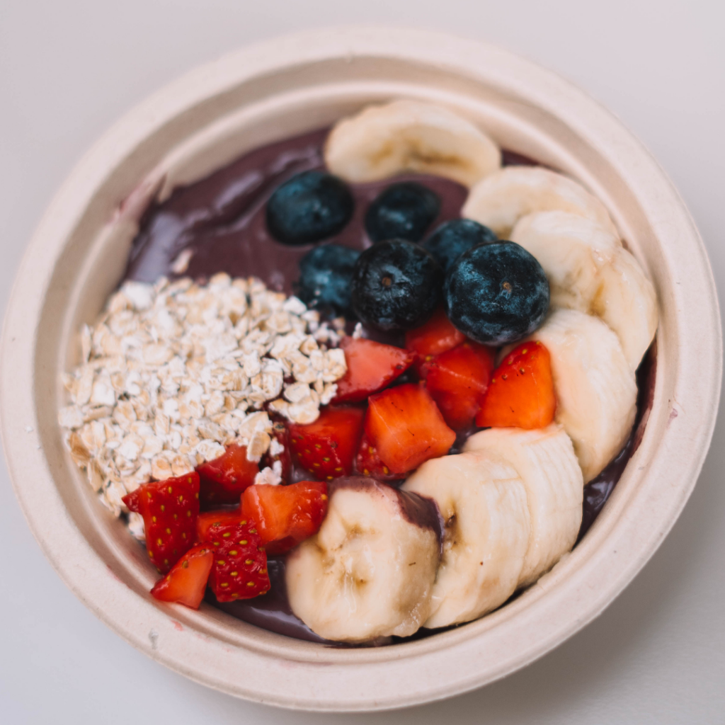 A bowl with acai smoothie topped with sliced bananas, strawberries, blueberries, and a portion of oats—perfect for starting your day in the Wildlight Yulee Florida community.