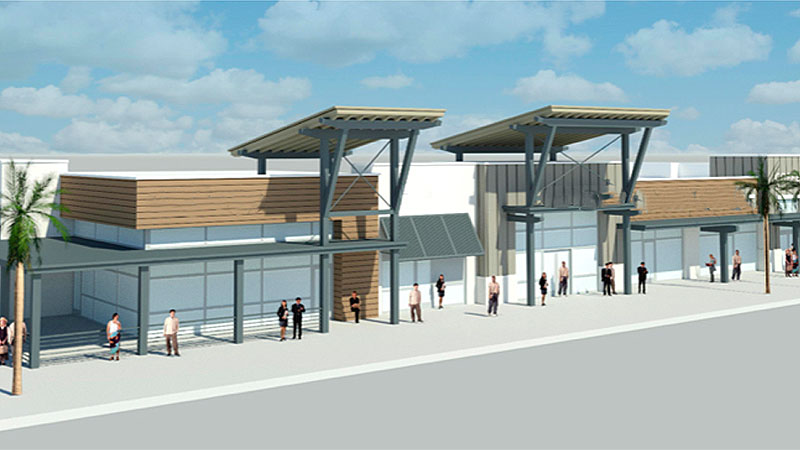 A modern strip mall with glass storefronts, wooden and metal accents, and people strolling beneath a partly cloudy sky reflects the vibrant atmosphere of the Wildlight Yulee Florida community.